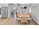 Spacious dining area with modern table set and view to living room with stainless steel refrigerator at 432 Palmetto Ct, Venice, FL 34285