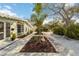 Landscaped walkway leading up to the front of the home with tropical plants at 432 Palmetto Ct, Venice, FL 34285