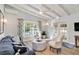 Airy living room showcases wood flooring, comfortable sofa, stylish chairs, and lots of light at 432 Palmetto Ct, Venice, FL 34285