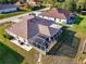 Aerial view of a home featuring a spacious screened lanai, manicured lawn, and proximity to neighboring properties at 4332 Big Leaf St, North Port, FL 34286