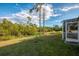 A lush backyard shows a view of a pond and trees, with a glimpse of the screened-in patio at 4332 Big Leaf St, North Port, FL 34286