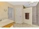 Bathroom with shower, cream cabinets, window and neutral tile flooring at 4332 Big Leaf St, North Port, FL 34286