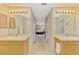 Bathroom with dual vanities, tile floors, and hall that leads to bedroom at 4332 Big Leaf St, North Port, FL 34286