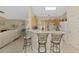 Kitchen with breakfast bar, white appliances, and natural wood cabinets at 4332 Big Leaf St, North Port, FL 34286