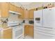 Well-lit kitchen with white appliances, ample counter space, and wooden cabinets at 4332 Big Leaf St, North Port, FL 34286