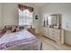 Bright bedroom featuring a large double bed, decorative window treatments and stylish wooden furniture at 4425 Corso Venetia Blvd # A20, Venice, FL 34293