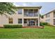 Rear exterior view with a screened patio, lush greenery, and well-maintained lawn at 4425 Corso Venetia Blvd # A20, Venice, FL 34293