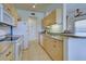 Bright kitchen with light wood cabinetry, appliances, and granite countertops at 4425 Corso Venetia Blvd # A20, Venice, FL 34293