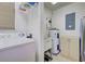 Bright laundry room with a washing machine, shelving and water heater with utility sink at 4425 Corso Venetia Blvd # A20, Venice, FL 34293