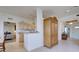 Open-concept living area with tiled floors, storage cabinet, and view into kitchen and entry at 4425 Corso Venetia Blvd # A20, Venice, FL 34293