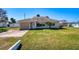 Wide backyard view with a partially shaded lawn and some tropical plants at 4784 Argonaut Rd, Venice, FL 34293