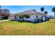 Angle view of a single-story home with a well-kept lawn and some tropical landscaping at 4784 Argonaut Rd, Venice, FL 34293