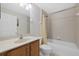 Well-lit bathroom features a shower-tub combo with tiled walls and neutral-toned vanity at 5194 Layton Dr, Venice, FL 34293