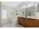 Main bathroom with double sink vanity, large mirror, soaking tub, and walk-in shower at 5194 Layton Dr, Venice, FL 34293