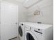 Modern laundry room with front loading washer and dryer and convenient storage shelving at 5194 Layton Dr, Venice, FL 34293