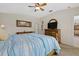 Primary bedroom with ceiling fan, dresser, decorative artwork and neutral-colored walls at 5194 Layton Dr, Venice, FL 34293
