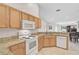 Bright kitchen featuring a white oven and microwave, stone counter tops, and tile flooring overlooking the backyard at 5255 Andris St, North Port, FL 34288