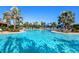 Large community pool with lounge chairs, umbrellas, and palm trees, a perfect place to relax at 5389 Trails Bend Ct, Sarasota, FL 34238