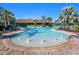 Community pool with fountains, lounge chairs, palm trees and community clubhouse in the background at 5389 Trails Bend Ct, Sarasota, FL 34238