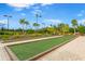 Outdoor bocce ball court with palm trees and benches surrounded by lush landscaping and lighting at 5505 Cantucci St, Nokomis, FL 34275