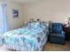 Cozy bedroom features a starfish-themed comforter, a large window, and comfortable seating at 5800 Niblick Pl, North Port, FL 34287