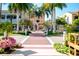 Street view of buildings with palm trees and beautiful landscaping and flowers at 5800 Niblick Pl, North Port, FL 34287