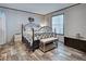 Bright bedroom featuring a metal bedframe, neutral colored walls, and wood-look flooring at 6665 Keystone Ct, North Port, FL 34287