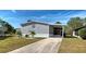 Charming gray home featuring well-maintained landscaping and a covered carport in a lovely community at 6665 Keystone Ct, North Port, FL 34287