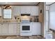 Bright kitchen with white cabinets, stainless steel stove, and wood-look floors at 6665 Keystone Ct, North Port, FL 34287