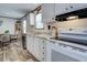 Bright kitchen with stainless steel dishwasher, white cabinets, and wood-look floors at 6665 Keystone Ct, North Port, FL 34287