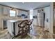 Kitchen with island, white cabinets, stainless steel refrigerator, and wood-look floors at 6665 Keystone Ct, North Port, FL 34287