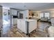 Kitchen with island, white cabinets, stainless steel refrigerator, and wood-look floors at 6665 Keystone Ct, North Port, FL 34287