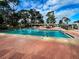 Sunny pool featuring a brick surround and an outdoor area with tables and chairs for residents to relax at 6665 Keystone Ct, North Port, FL 34287