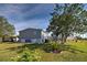 Rear view of home with wooden stairs leading to the back door and well maintained landscaping at 6665 Keystone Ct, North Port, FL 34287