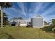 Rear view of home with wooden stairs leading to the back door and well maintained landscaping at 6665 Keystone Ct, North Port, FL 34287