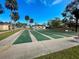 Beautiful shuffleboard courts next to a pond and palm trees under a bright blue sky at 6665 Keystone Ct, North Port, FL 34287