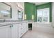 Bathroom featuring double sinks with decorative drawer pulls and a soaking tub at 707 Petrel Way, Venice, FL 34285