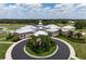 Gorgeous view of the clubhouse featuring a circular driveway and palm trees at 707 Petrel Way, Venice, FL 34285