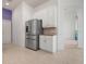 Kitchen featuring a stainless steel refrigerator, white cabinets, and tile flooring at 707 Petrel Way, Venice, FL 34285