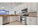 Modern kitchen features stainless steel appliances, tile backsplash, granite countertops, and sleek white cabinetry at 707 Petrel Way, Venice, FL 34285