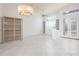 Open concept living room featuring tile floors, custom shelving, and decorative glass front doors at 707 Petrel Way, Venice, FL 34285