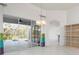 Bright living room with tile floors, stylish lighting, and sliding doors leading to the pool at 707 Petrel Way, Venice, FL 34285
