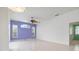 Bright open room with tile floor, large ceiling fan, three windows, and neutral paint, offering versatile living space at 707 Petrel Way, Venice, FL 34285