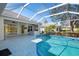 View of the pool and patio area with outdoor kitchen and lush landscaping at 707 Petrel Way, Venice, FL 34285