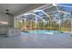 View of the screened-in pool area featuring an outdoor kitchen and lush landscaping at 707 Petrel Way, Venice, FL 34285