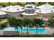 Aerial view of the community pool, showcasing the building architecture and surrounding trees at 707 Petrel Way, Venice, FL 34285