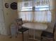 Cozy dining area with a simple table, chairs, and bright natural light from the window at 718 S Green Cir, Venice, FL 34285