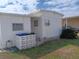 Side view of the home with a cement block base and a small bush at 718 S Green Cir, Venice, FL 34285