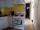Functional kitchen with a white gas range, bright yellow walls, and ample cabinet space at 718 S Green Cir, Venice, FL 34285