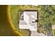 Aerial view of a home with a screened lanai and neutral tile roof near the water at 803 Carnoustie Dr, Venice, FL 34293